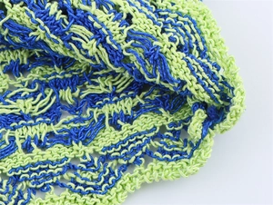 Macro detail of the blue and lime green knitted mesh texture on this stylish women's outfit