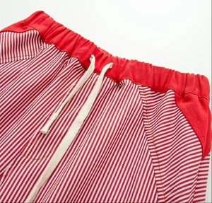Detail of red elastic waistband with white drawstring on striped wide leg pants