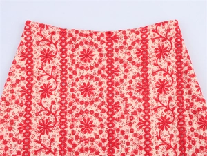 Detail of red floral embroidery and delicate eyelet lace on beige fabric set