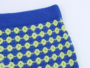 Detailed close-up of blue and green checkered crochet knit fabric with clear stitching