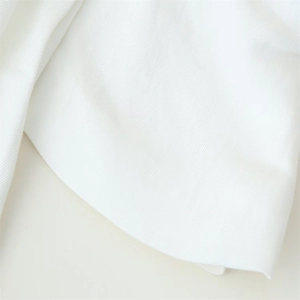 Close-up of white high-density twill woven fabric showing detailed textile texture