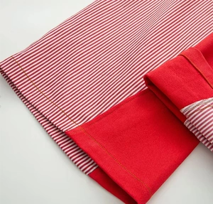 Detail of red and white striped wide leg pants with yellow contrast stitching and red lining