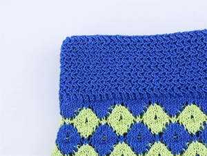 Detailed macro view of the royal blue and lime green argyle knitted fabric texture