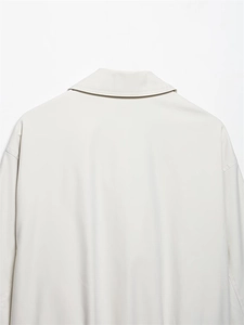 Detail of minimalist cream flight jacket showing back collar and dropped shoulder design