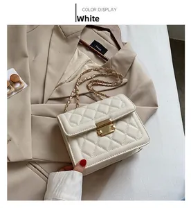 Detail of white quilted leather texture with gold metal lock and chain strap