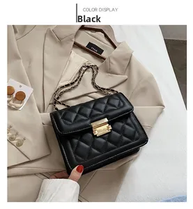 Detail of black quilted leather shoulder bag with gold chain strap and metal lock
