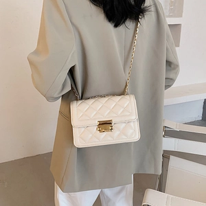 Quilted crossbody bag in cream white with gold chain strap on female model