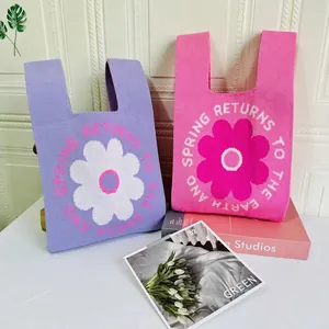 Pink and purple knit tote bags with floral patterns and Spring Returns text design