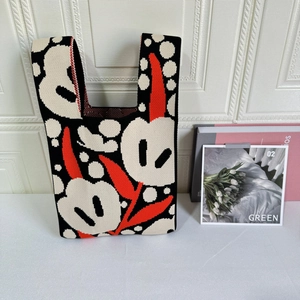 Close-up of contrast floral pattern on a thick knit tote bag with U-shaped handles