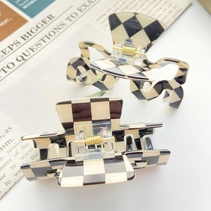 Checkered hair claw clips set in black and white matte resin with gold metal spring
