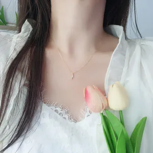 Close-up of minimalist gold lightning bolt pendant necklace with cubic zirconia on model