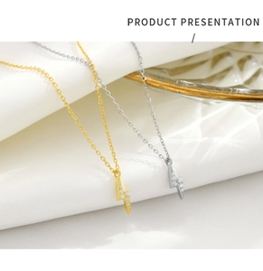 Detailed view of silver and gold lightning pendants with sparkling micro-pave zircons