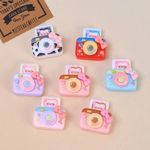 Détail macro de mini caméras en résine colorées avec nœuds doux et motifs cartoon