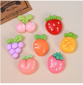 Vue détaillée de breloques en résine de fruits colorés, fraise, cerise et carotte