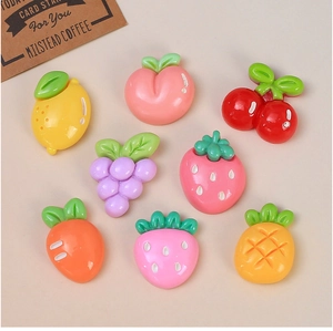 Vue à plat de huit breloques colorées en résine fruits et légumes pour créations DIY