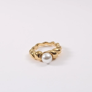 Macro detail of twisted rope gold ring band featuring a centered white pearl inlay