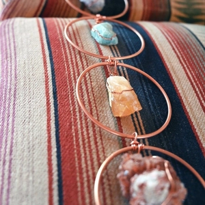 Detail of handcrafted bohemian wall decor with raw crystals and antique bronze rings