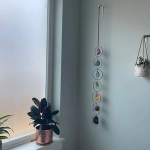 Detail of seven chakra raw stone wall hanging with natural crystals and metal rings