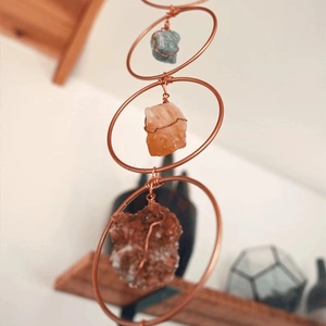 Detailed macro view of bohemian handmade wall decor with copper rings and natural raw gemstones
