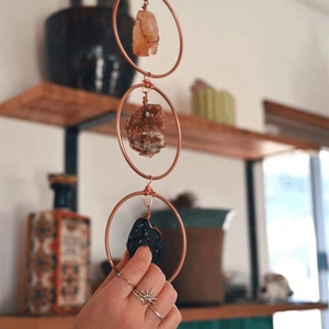 Detail of bohemian wall decor with three raw crystals hand-wrapped in copper rings