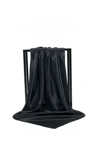 Detail showing the glossy texture and drape of a 90cm black satin silk square scarf