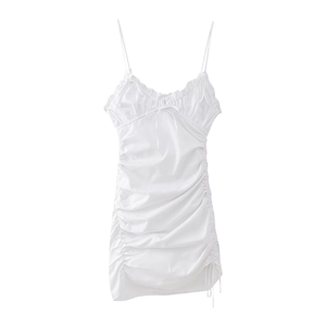 Close-up of white mini dress featuring V-neckline with bow and side ruched detailing