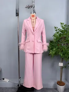 Pink women's two-piece suit detail featuring elegant feather cuffs on slim blazer sleeves