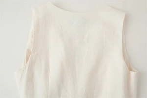Close-up of crew neck and shoulder detail showing the premium linen texture fabric