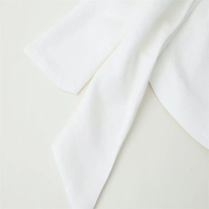 Close-up of premium white twill fabric detail showing rich texture and clean stitching