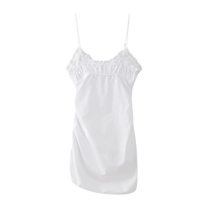 Close-up of sleek white satin slip dress featuring fine straps and pleated ruffle details