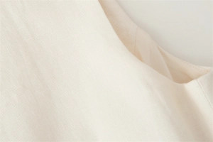 Detail of cream sleeveless top showing neat stitching and textured linen fabric