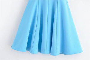 Detailed macro view of the light blue pleated dress hem featuring high-quality stitching