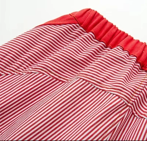 Detail of red and white striped wide leg trousers with elastic waistband texture