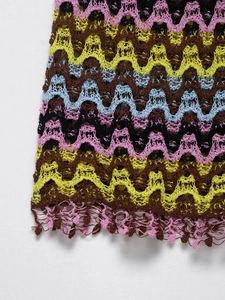 Detailed close-up of colorful crochet knit with zigzag pattern and bohemian fringe accents