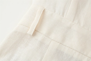 Detailed close-up of the waistband on beige cotton-linen blend trousers with belt loops