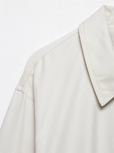Detailed close-up of shoulder stitching and premium twill fabric on cream pilot jacket