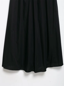 Close-up of black midi dress hem showing clean stitching and premium matte fabric texture