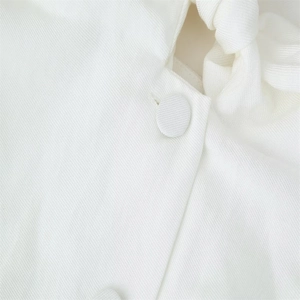 Detailed macro view of white twill fabric texture and matching fabric-covered button
