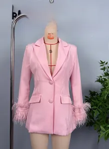 Close-up of pink blazer sleeves featuring dense feather cuffs and button detailing