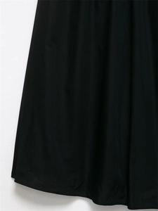 Detailed close-up of the matte black dress hem with high-quality stitching and fabric texture