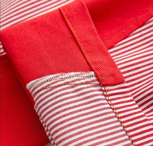 Macro shot of red and white striped fabric showing high-quality stitching and seam detail