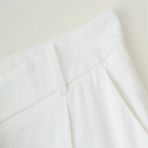 Detail of white high-waist trousers featuring twill fabric texture and belt loops