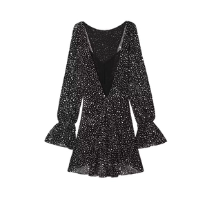 Detailed close-up of the V-neckline and black and white polka dot pattern on the dress