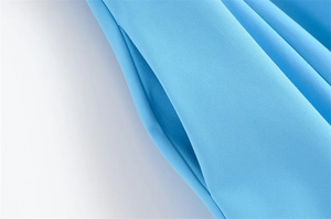Detail of hidden side pocket on light blue dress with fine textured fabric and clean seams