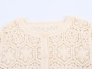 Detailed close-up of beige crochet cardigan featuring intricate floral hollow knit patterns