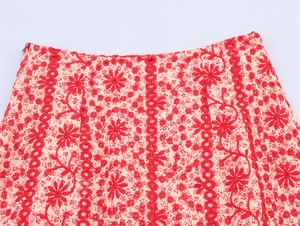 Detail of red floral eyelet embroidery on white cotton fabric with invisible zipper