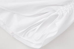 Detailed view of white fabric texture showing fine twill weave and drawstring design details