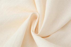 Detailed close-up of the breathable cream cotton-linen fabric texture with natural folds
