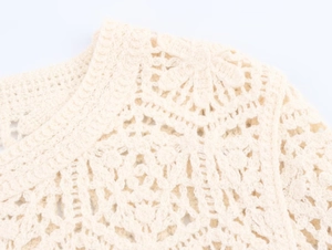 Close-up of beige crochet long sleeve top with intricate hollow floral knit patterns