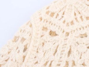 Macro shot of off-white crochet texture with intricate floral openwork pattern details